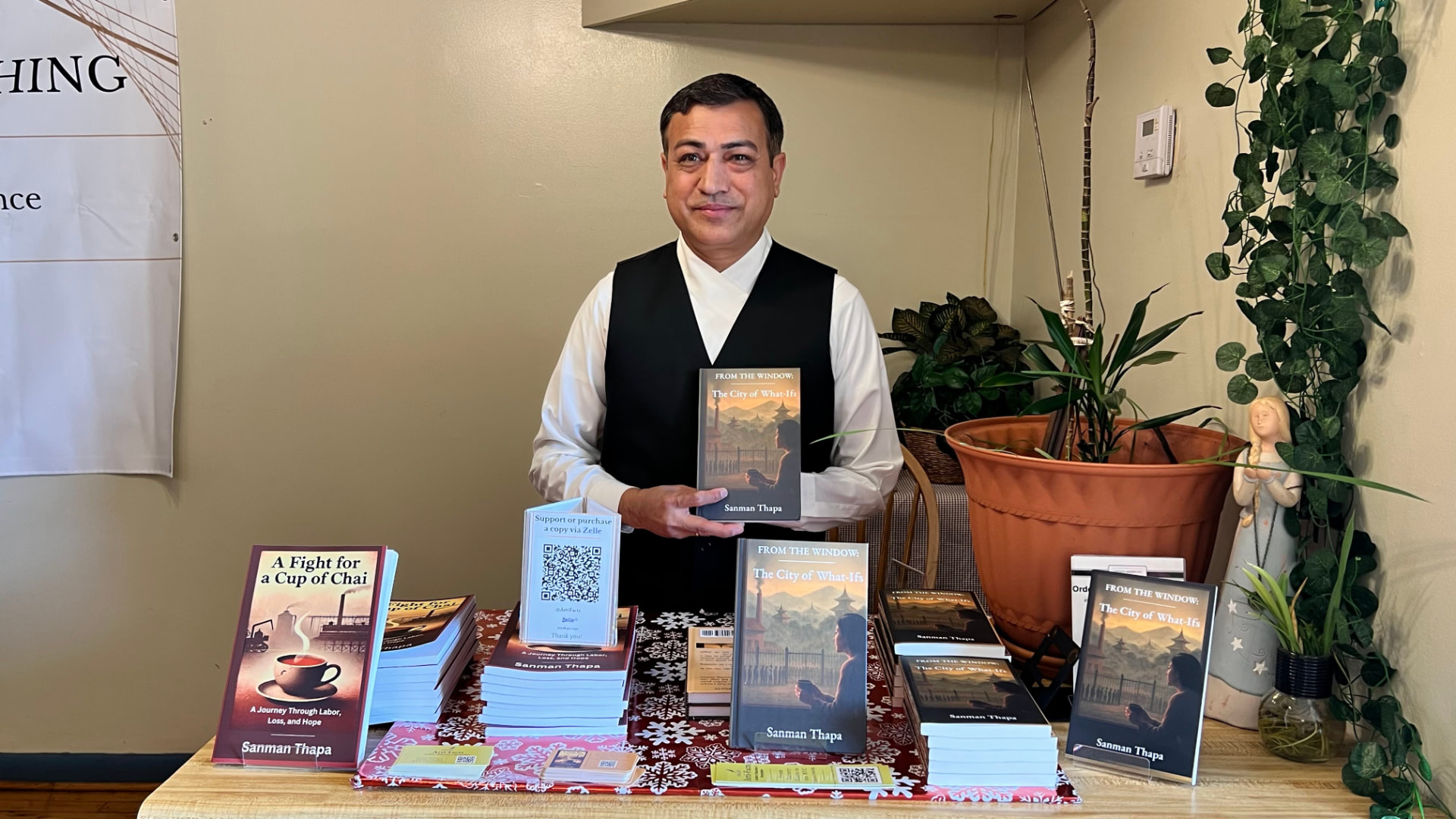 Sanman Thapa holding a copy of From the Window: The City of What Ifs