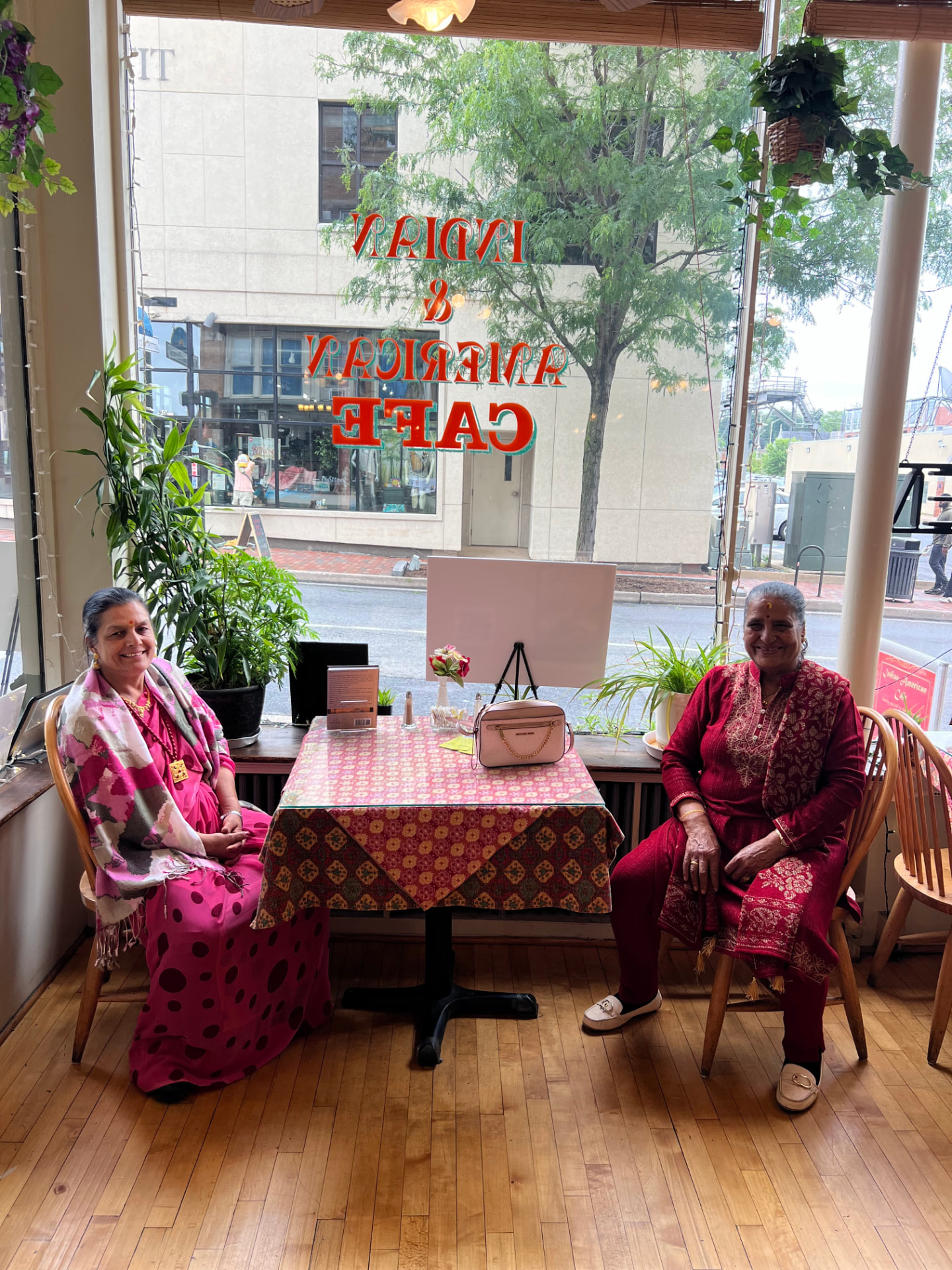 Two guests seated by the cafe window during the launch